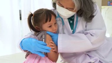 Enjeksiyon için Asyalı doktor şırıngası iğnesi, çocuklar koronavirüs ve grip önleme aşısı oluyor. Aşıdan gelen bağışıklık kavramı
