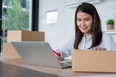 Mutlu Asyalı genç girişimci, Hold paketi ve gülümseme ev ofisindeki çevrimiçi alışveriş mağazasının başarısı, tüccar kavramı, küçük işletme, çevrimiçi ticaret ve eCommerce.