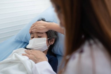 Asyalı çocuk doktoru doktor muayene için elini göğsüne koydu küçük bir kız hasta ve çocuğun kalp ciğerleri, iyi bir aile doktoru çocuğu evde ziyaret ediyor, sağlık ve çocukluk konsepti için ilaç..