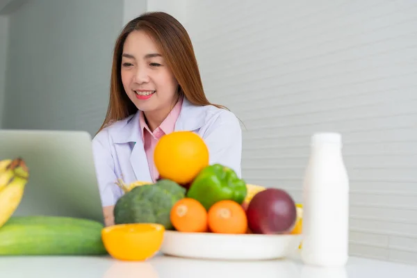 患者や減量のアドバイスのためのバランスのとれた是正食事計画のためのラップトップコンピュータに入力するアジアの笑顔の女性栄養士の肖像画 健康的なライフスタイル 健康的な食べ物 食事の概念 — ストック写真