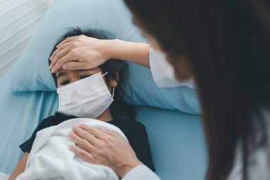 Asyalı çocuk doktoru doktor muayene için elini göğsüne koydu küçük bir kız hasta ve çocuğun kalp ciğerleri, iyi bir aile doktoru çocuğu evde ziyaret ediyor, sağlık ve çocukluk konsepti için ilaç..