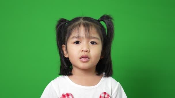 在绿屏背景上描绘快乐而有趣的亚洲小女孩 一个看着相机的孩子 学龄前儿童的梦想充满了精力 感觉健康和好的概念 — 图库视频影像