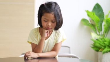 Portrait of Asian child 5 year old and to collect hair and Place her hands on her chin and make thinking pose, She is Happiness, radiance in youth, Education Concept