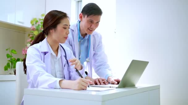 两位亚洲世代的医生在电脑上讨论团队合作测试结果 两位健康专家讨论 找出拯救生命的治疗方案 合作医疗概念 — 图库视频影像
