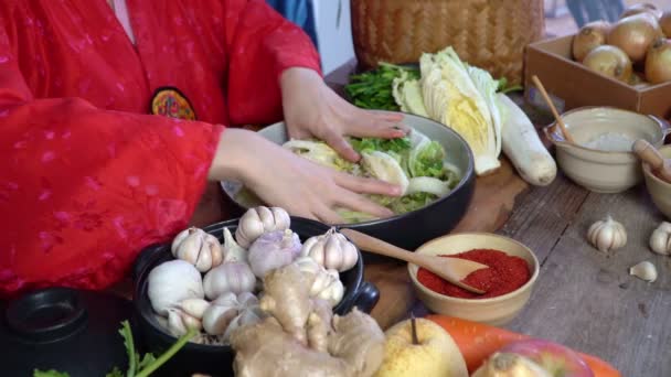 한국의 아시아 여자들은 손으로 소금을 뿌리고 고추가루 재료로 김치를 담근다 — 비디오
