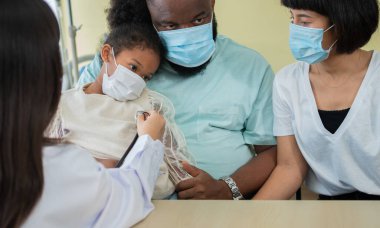 Asyalı kadın pediyatrist doktor muayene için stetoskop tutuyor küçük bir kız hasta ve çocuğun kalp ciğerleri, iyi aile doktoru çocuğu evde ziyaret ediyor, sağlık ve çocukluk konsepti için ilaç alıyor..