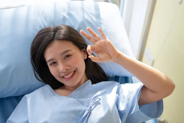 Felice Paziente Asiatica Sorridente Sdraiata Sul Letto Mostra Simbolo Mostrare — Foto Stock