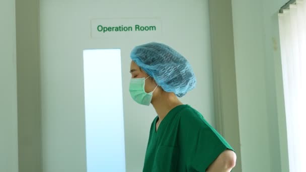 アジアの外科医の肖像は ストレスや過労 不安や新しい緊急事態の操作エラー後に病院の手術室の前を歩く — ストック動画