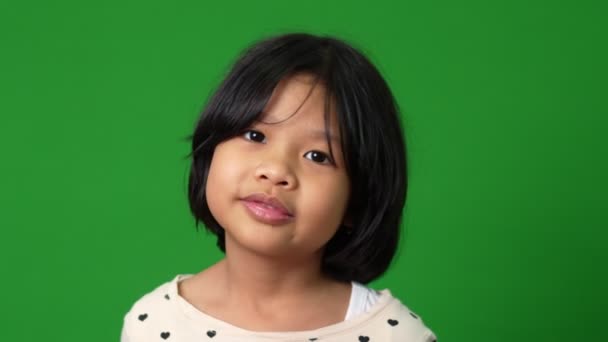 緑の画面の背景に幸せと面白いアジアの子供の少女の肖像画 子供のカメラを見て 就学前の子供は健康的で良い概念を感じるエネルギーで満たされる夢 — ストック動画