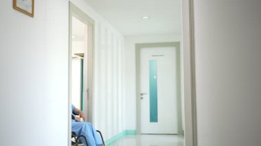 Kazadan sonra tekerlekli sandalyedeki Asyalı hasta ve doktorla konuşmak, fizyoterapist hastaya nasıl iyileşeceğini, cerrahın tekerlekli sandalyeye bağlı hastayı ittiğini, kazadan kaynaklanan ağrıyı,