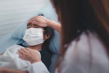 Asyalı çocuk doktoru doktor muayene için elini göğsüne koydu küçük bir kız hasta ve çocuğun kalp ciğerleri, iyi bir aile doktoru çocuğu evde ziyaret ediyor, sağlık ve çocukluk konsepti için ilaç..