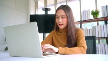 Portre mutlu genç programcı Asyalı kadın yeni teknoloji ofisinde çalışıyor ve bilgisayarla kodlama programı yapıyor ve tamamen yaratıcı. Zeki girişimci kadın kavramı.