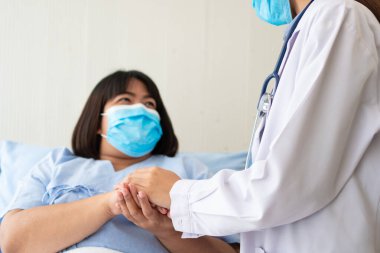 Asyalı kadın doktorlar hastanın elini tutarlar ve hasta sağlığını kontrol ederken ona tıbbi tavsiyelerde bulunurlar. Bakım ve şefkat kavramı, doğum öncesi bakım, kürtaj tehdidi