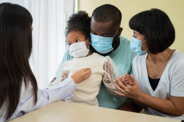 Asyalı kadın pediyatrist doktor muayene için stetoskop tutuyor küçük bir kız hasta ve çocuğun kalp ciğerleri, iyi aile doktoru çocuğu evde ziyaret ediyor, sağlık ve çocukluk konsepti için ilaç alıyor..