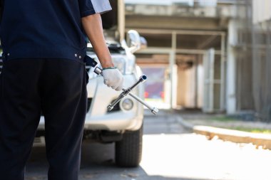 Bozuk bir arabanın tekerleğini değiştirmek için araba tamircisinin eline odaklan, alet ya da ekipman kullan, sorunları profesyonel araç tamiri ve sigorta konseptiyle çözmeye çalış