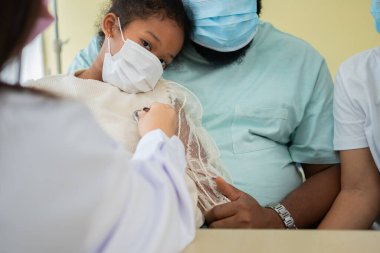 Asyalı kadın pediyatrist doktor muayene için stetoskop tutuyor küçük bir kız hasta ve çocuğun kalp ciğerleri, iyi aile doktoru çocuğu evde ziyaret ediyor, sağlık ve çocukluk konsepti için ilaç alıyor..