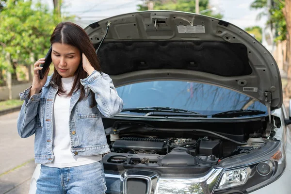 怒っているアジアの女性と路上で車の故障後の支援を求める携帯電話を使用しています 車両エンジンの問題や事故や専門の機械工からの緊急支援の概念 — ストック写真