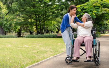 Tekerlekli sandalyedeki hastayla ilgilenen Asyalı dikkatli bir bakıcı ya da hemşire. Bakıcının, birikimin ve sağlık sigortasının özenle mutlu emeklilik kavramı. Mutlu bir aile.