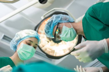 Profesyonel cerrahlar için düşük açılı ameliyat ekibi ameliyathanede, cerrah, asistan ve hemşireler bir hastaya, sağlık kanseri ve hastalık tedavi konseptinde ameliyat yapıyor.