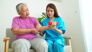 Asian Caregiver nurse doing physical therapy assistance and support teach body and muscle exercises to elderly women. Physical therapy and senior citizens rehabilitation concept.