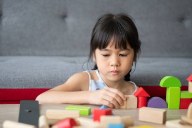Sevimli Asyalı küçük kız renkli oyuncak bloklarıyla oynuyor çocuklar anaokulunda ya da kreşte eğitici oyuncaklarla oynuyor. Çocuk gelişimi konseptinin yaratıcı oyunu, çocuk yuvasında çocuk..