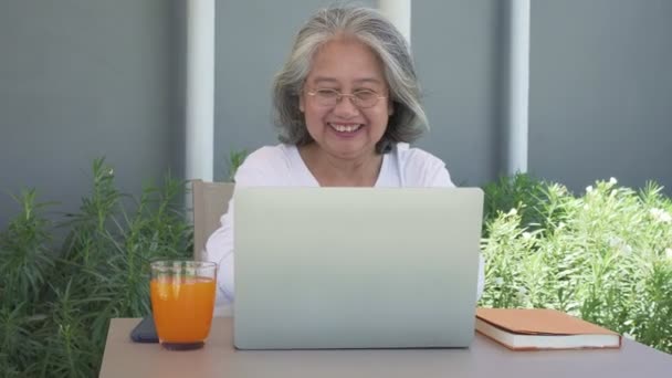 Feliz Anciana Asiática Con Gafas Usando Ordenador Portátil Escritorio Patio — Vídeos de Stock