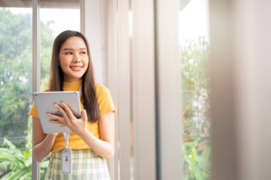 Mutlu Asyalı genç kadın girişimci mutlu ve heyecanlı bir şekilde gülümsüyor. İş yerindeki mutlu kız, iş yerindeki başarı işareti teması mesajını aldıktan sonra. Uzaklık öğrenme çevrimiçi eğitim ve çalışma.