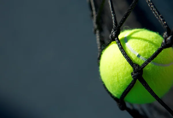 Теннисный мяч в сетке — стоковое фото