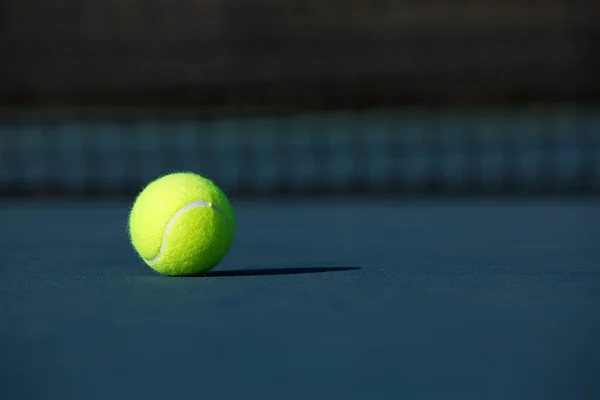 Tennisboll på en blå domstol — Stockfoto