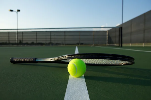 Pelota de tenis y raqueta en la cancha —  Fotos de Stock