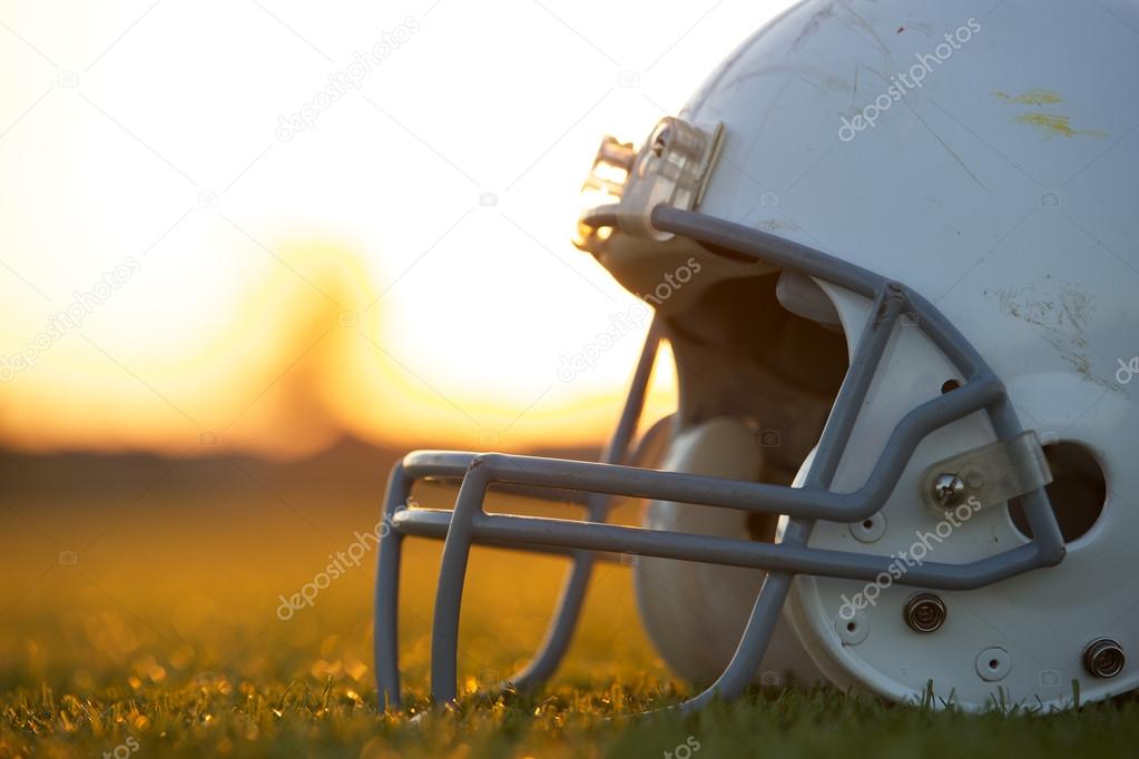 American Football Helmet on the Field at Sunset