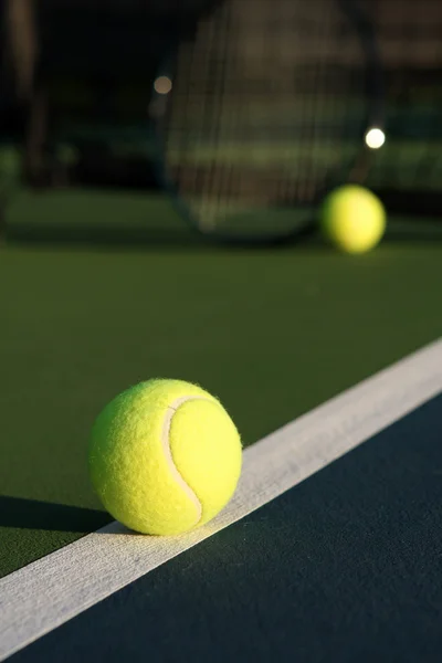 Теннисный мяч с ракеткой на заднем плане — стоковое фото