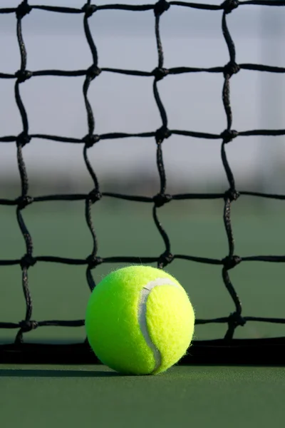 Теннисный мяч против сети — стоковое фото