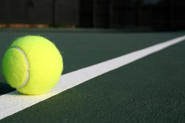 Pelota de tenis en una línea diagonal de pista — Foto de Stock