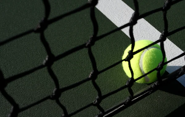 Tenisový míč přes síť soud — Stock fotografie