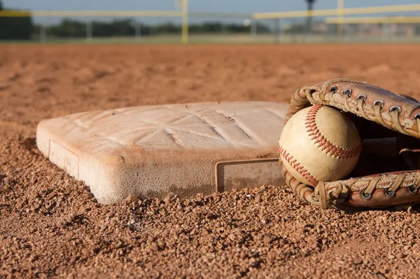 Beisebol em uma luva perto da base — Fotografia de Stock