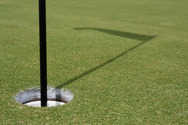 Trou de golf et ombre du drapeau — Photo