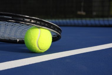Tenis top ve raket üzerinde mavi bir mahkeme
