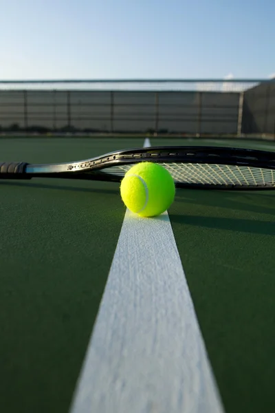 Pelota de tenis y raqueta en una cancha azul —  Fotos de Stock