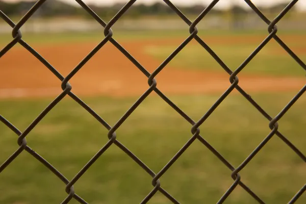 Campo de beisebol visto através de uma cerca Fotos De Bancos De Imagens Sem Royalties