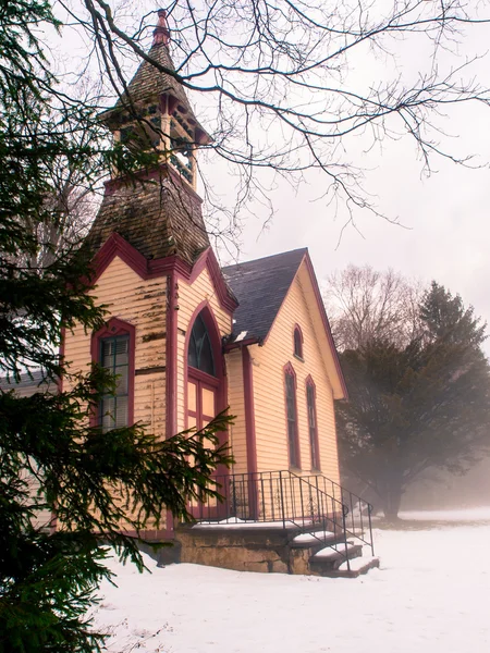 Velho amarelo vermelho aparado igreja na neve — Fotografia de Stock
