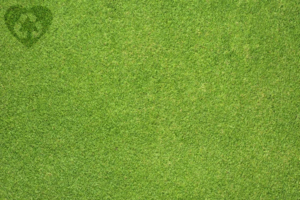 Reciclagem de ícone de coração na textura de grama verde e fundo — Fotografia de Stock