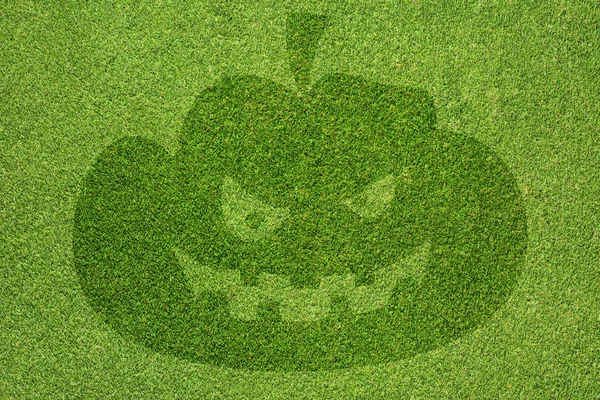 Halloween pompoen op groen gras textuur en achtergrond — Stockfoto