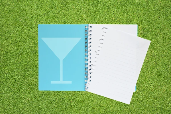 Boek met drank icon op gras achtergrond — Stockfoto