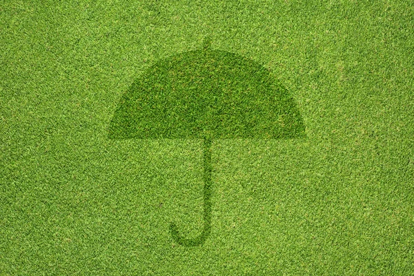 Ícone de guarda-chuva na textura de grama verde e fundo — Fotografia de Stock