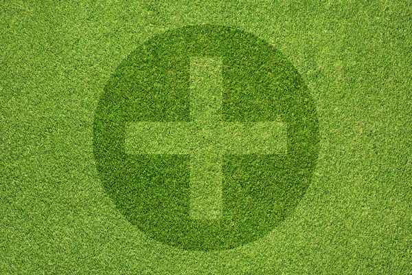 Plus on green grass texture and background — Stock Photo, Image