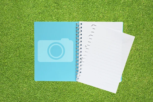 Boek met camera-icoontje op gras achtergrond — Stockfoto