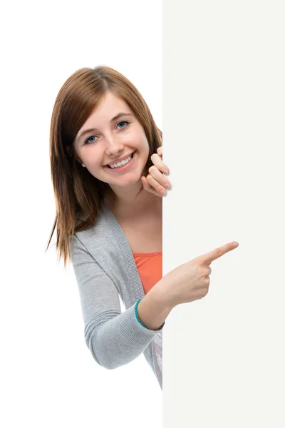 Adolescente menina aponta o dedo para uma placa em branco — Fotografia de Stock