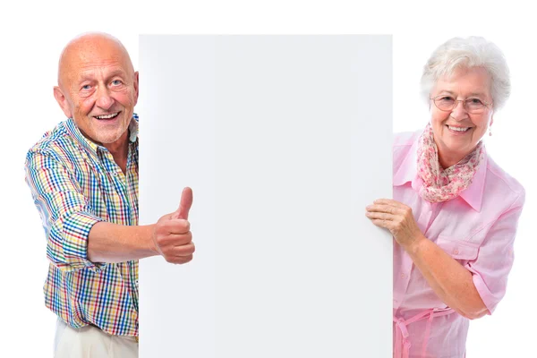 Felice sorridente coppia anziana con una scheda vuota — Foto Stock