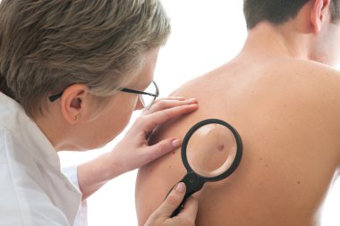 dermatolog bir beni ele alıyor.